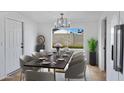 Formal dining room with modern chandelier and view to backyard at 2958 E Contessa St, Mesa, AZ 85213