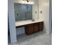 Bathroom vanity featuring a white countertop, dark wood cabinetry, modern lighting, and large mirror at 3010 E Cedar Dr, Chandler, AZ 85249