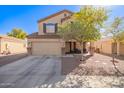 Two story home with an attached garage, desert landscaping and a covered porch seating area at 317 W Settlers Trl, Casa Grande, AZ 85122