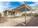 Outdoor living space with a large pergola, fire pit, and low-maintenance desert landscaping at 39559 N Prairie Ln, Anthem, AZ 85086