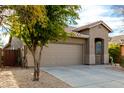 View of home showcasing the attached two-car garage, desert landscaping, and neutral color palette at 39559 N Prairie Ln, Anthem, AZ 85086