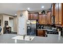 Well-equipped kitchen featuring dark wood cabinets, stainless steel appliances, breakfast bar and tiled backsplash at 42072 W Dorsey Dr, Maricopa, AZ 85138