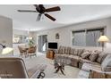 Relaxing living room features ceiling fan and a large window with a comfortable couch and a view at 5525 E Thomas Rd # O8, Phoenix, AZ 85018