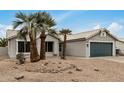 Single-story home featuring desert landscaping with palm trees and an attached garage at 6303 E Preston St, Mesa, AZ 85215