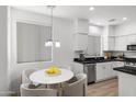 Bright kitchen featuring white cabinets, stainless steel appliances, and an adjacent dining area at 6392 W Pontiac Dr, Glendale, AZ 85308
