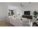 Bright, open living room with light floors, a ceiling fan, and access to the dining area at 6392 W Pontiac Dr, Glendale, AZ 85308