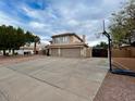 View of the home's wide driveway with a basketball hoop, leading up to a three-car garage at 6544 E Portia St, Mesa, AZ 85215