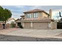 Exterior view of the home with a driveway, three-car garage, desert landscaping, and a second story at 6544 E Portia St, Mesa, AZ 85215