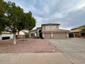 Beautiful home featuring well-maintained desert landscaping, mature trees, and a well manicured lawn at 6544 E Portia St, Mesa, AZ 85215