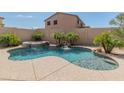 Beautiful backyard pool with a waterfall feature, spa, and mature landscaping for added privacy at 7381 W Paso Trl, Peoria, AZ 85383