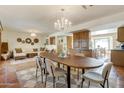 Bright dining area with a chandelier, a wooden table, and direct access to the living room at 7526 E Edgemont Ave, Scottsdale, AZ 85257