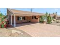 View of the home's covered carport and brick-paved driveway, framed by blooming bougainvillea at 7526 E Edgemont Ave, Scottsdale, AZ 85257
