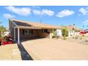 Single-story home featuring an extended brick driveway and a cozy carport covered with blooming vines at 7526 E Edgemont Ave, Scottsdale, AZ 85257