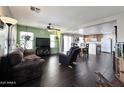 Inviting living room with dark wood floors, ceiling fan, and open access to the kitchen at 1042 S Cheshire Ln, Gilbert, AZ 85296