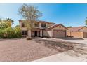 Two-story home showcasing a front yard with desert landscaping and a large attached two-car garage at 1114 S Grenoble --, Mesa, AZ 85208