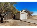 Detached two-car garage with shade tree and a gravel driveway at 11354 W Carousel Dr, Arizona City, AZ 85123