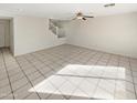 Open living room with neutral paint, tile flooring, and a ceiling fan at 11595 W Holly St, Avondale, AZ 85392