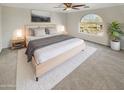 Cozy main bedroom featuring an arched window and a plush carpet at 11595 W Holly St, Avondale, AZ 85392