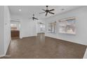 Spacious, bright living room with tile floors, large windows, and ceiling fans at 11910 W Daley Ct, Sun City, AZ 85373