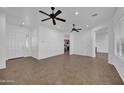 Bright, open-concept living room with tile floors, ceiling fans, and white walls at 11910 W Daley Ct, Sun City, AZ 85373