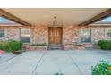 Inviting covered front porch with brick columns and a beautiful wooden front door at 1201 W Dahlia Dr, Phoenix, AZ 85029