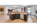 Stylish kitchen bar area with dark cabinetry, stainless steel appliances, and tile backsplash at 13594 W Port Royale Ln, Surprise, AZ 85379