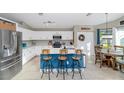 Bright kitchen with white cabinetry, stainless steel appliances, a breakfast bar, and a cozy dining area at 1363 N Mckenna Ln, Gilbert, AZ 85233