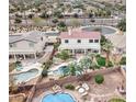 Expansive backyard oasis featuring a pool, spa, rock features, lush landscaping, and patio area for entertaining at 14674 W Windsor Ave, Goodyear, AZ 85395