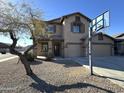 Charming two-story home with three-car garage, desert landscaping, and a basketball hoop at 1637 W Green Tree Dr, San Tan Valley, AZ 85144