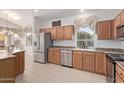 Well-lit kitchen with stainless steel appliances, wooden cabinetry, and tiled flooring at 17697 W Sunbelt Dr, Surprise, AZ 85374