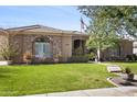 Traditional home with stone accents, a well-maintained lawn, and mature landscaping at 19727 E Julius Rd, Queen Creek, AZ 85142