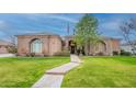 Beautiful home featuring a lush green lawn, desert landscaping and stone accents at 19727 E Julius Rd, Queen Creek, AZ 85142