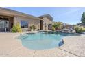 Sparkling pool with rock waterfall feature and manicured landscaping creates a private outdoor oasis at 19727 E Julius Rd, Queen Creek, AZ 85142