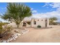 Beautiful southwestern home with desert landscaping, a stone walkway, and an arched entryway, perfect for relaxing at 19927 W Meadowbrook Ave, Litchfield Park, AZ 85340