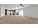 Open-concept living space with tile flooring, wood cabinets, ceiling fan, and sliding door access at 2815 W Charleston Ave, Phoenix, AZ 85053