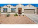 Charming single-story home with desert landscaping, two-car garage, and a welcoming red front door at 30876 W Verde Ln, Buckeye, AZ 85396