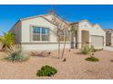 Well-maintained single story home with a two-car garage and desert landscaping, a sidewalk, and street views at 30876 W Verde Ln, Buckeye, AZ 85396