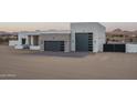 Modern home featuring a clean white design with gray garage doors, brick accents, and mountain views at 37931 N 31St Ave, Phoenix, AZ 85086