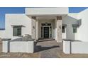 Inviting front entrance with stone pillars, a modern front door, pavers, and stylish lighting fixtures at 37931 N 31St Ave, Phoenix, AZ 85086