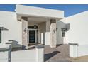 Inviting front entrance with stone pillars, a modern front door, pavers, and stylish lighting fixtures at 37931 N 31St Ave, Phoenix, AZ 85086