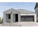 Home exterior exhibiting modern curb appeal, highlighted by its gray finish, a two-car garage, and manicured front yard at 5736 S Daisy Patch Pl, Phoenix, AZ 85040