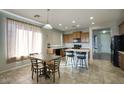 Open concept kitchen with a dining area featuring tile flooring, a center island, and barstool seating at 6109 S 30Th Dr, Phoenix, AZ 85041