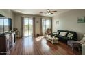 Cozy living room with wood flooring, sliding glass doors to the backyard, and neutral paint at 6109 S 30Th Dr, Phoenix, AZ 85041