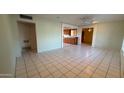 Spacious living room with neutral walls and tile floors, brightened by natural light from the large window at 6413 E Holly St, Scottsdale, AZ 85257