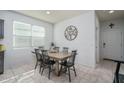 Bright dining area features tile flooring, a large window, and a stylish table with seating for six at 7734 W Florence Ave, Phoenix, AZ 85043