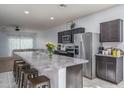 Open-concept kitchen with a large island, stainless steel appliances, and seamless transition to the living area at 7734 W Florence Ave, Phoenix, AZ 85043