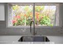 Stainless steel sink with garden window view of vibrant bougainvillea at 7920 E Via Camello -- # 49, Scottsdale, AZ 85258