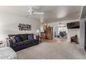 Comfortable living room with neutral carpet, ceiling fan, and a view into the kitchen and bonus room at 8012 E Monte Ave, Mesa, AZ 85209