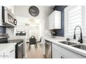 Updated kitchen features stainless steel appliances, white cabinets, a large sink, and views into the dining area at 809 N 11Th Ave, Phoenix, AZ 85007