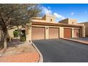 Multi-car garage with neutral paint, brown doors, and desert landscaping, set under a bright blue sky at 8344 N 21St Dr # I105, Phoenix, AZ 85021